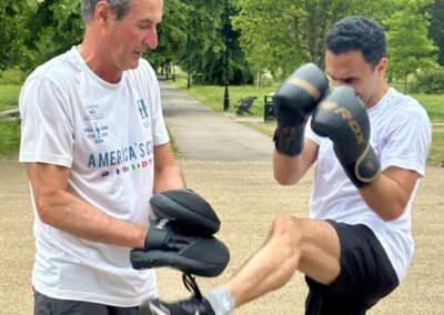 Two men doing boxing drills during an outdoor bootcamp in Clapham Common Bandstand after work
